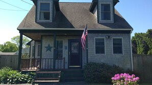 A two-story house with a porch, an American flag, and a star on the door. - Walk to the Beach! (Middletown)