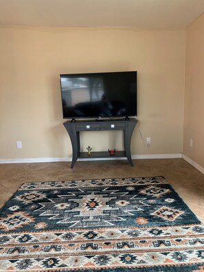 Relax in comfort with a flat-screen TV and a cozy area rug.