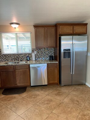 Enjoy cooking in this well-equipped kitchen with a refrigerator, dishwasher, and coffee maker.