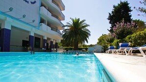 A swimming pool with lounge chairs and a palm tree. - Holiday Rendez Vous 4 - Two-room apartment on ground floor with garden (Pineto)