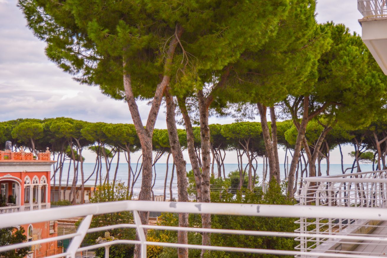 A coastal view with trees and a building in the background.