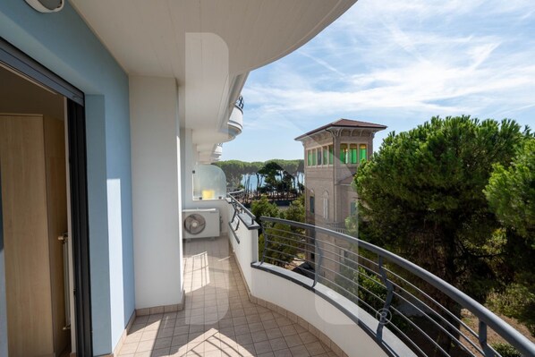 A balcony with a view of a building and trees.