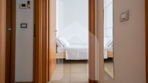 A hotel room with a bed, a door, and a mirror. - Holiday Rendez Vous 38 - Third floor apartment with pool view (Pineto)