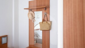 Une porte en bois avec un miroir, un chapeau et un sac à main accrochés à des crochets.