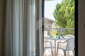 Enjoy a peaceful balcony with a view of the surrounding area, featuring a table and comfortable seating.