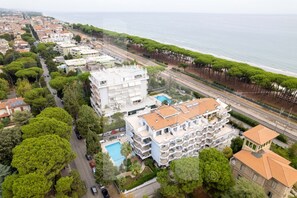 An aerial view of a coastal residential area with a large building featuring multiple balconies and a swimming pool. - Holiday RendeZ Vous 39 - Third floor apartment with side sea view (Pineto)