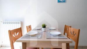 A dining table with four chairs, a potted plant, and a blue sign on the wall. - Holiday Rendez Vous 15 - Ground floor apartment with balcony and side sea view (Pineto)