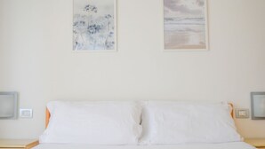 A bedroom with a bed, two framed artworks, and bedside tables. - Holiday Rendez Vous 16 - First floor apartment with balcony and pool view (Pineto)