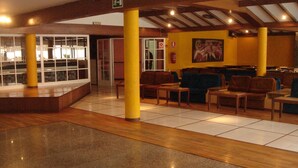 Un hall d’entrée avec un espace salon, un plancher en bois et une cloison en verre.