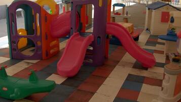 Een speelruimte voor kinderen met een glijbaan en klimconstructies.