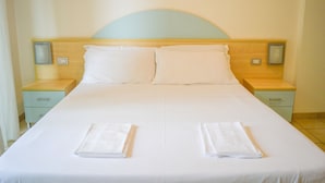 A hotel room with a large bed, two bedside tables, and a wooden headboard. - Holiday Rendez Vous 40 - Third floor apartment with side sea view (Pineto)