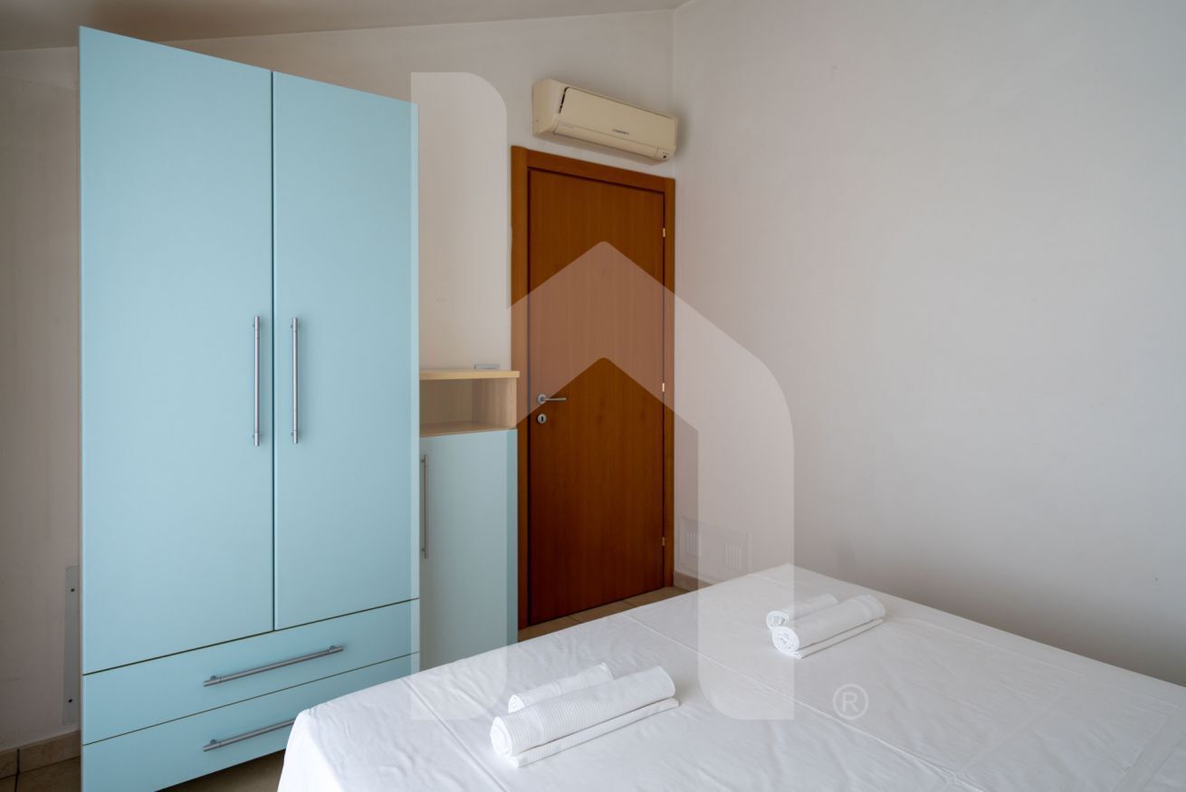 Ein Schlafzimmer mit einem Bett, einem Kleiderschrank und einer Tür.