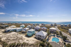 Stunning coastal homes surround a central pool, offering a scenic ocean view.