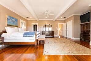 Relax in this serene bedroom with a large bed, matching bench, and classic dresser.