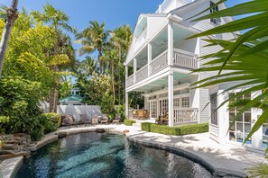 A two-story building with a pool, surrounded by palm trees and greenery. - Key West Oasis - Truman Annex Estate (Key West)