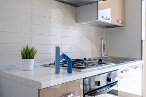 Réfrigérateur, un four, surface de cuisson, vaisselle et ustensiles