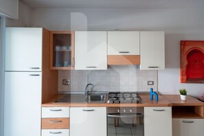 A modern kitchen with white cabinets, a stainless steel sink, a gas stove, and a dishwasher. - Holiday Rendez Vous 23 - First floor apartment with sea view (Pineto)