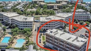 Vista aérea de un resort con varias edificaciones, una piscina y vista al océano.