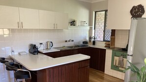 Eine moderne Küche mit weißen Schränken, einer Holzinsel und einem eingebauten Backofen.