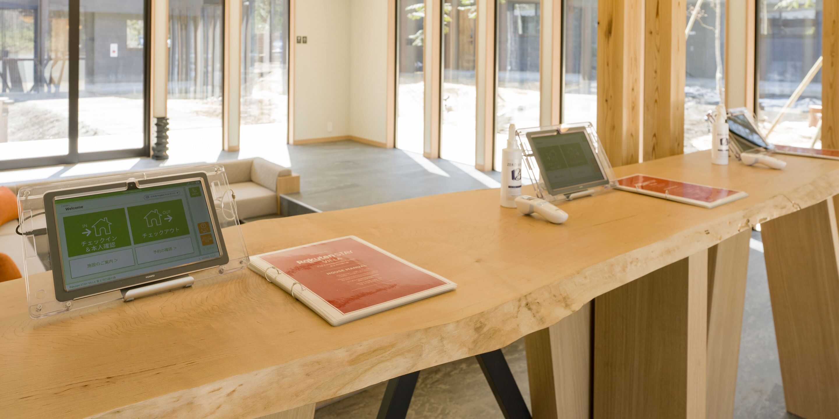 A reception desk with a digital kiosk, a tablet, and a brochure.