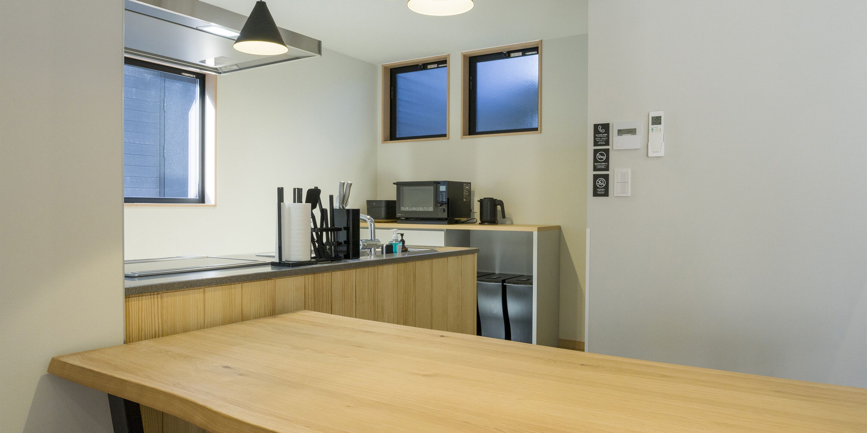 Una cocina moderna con encimera de madera, microondas, cafetera y refrigerador.