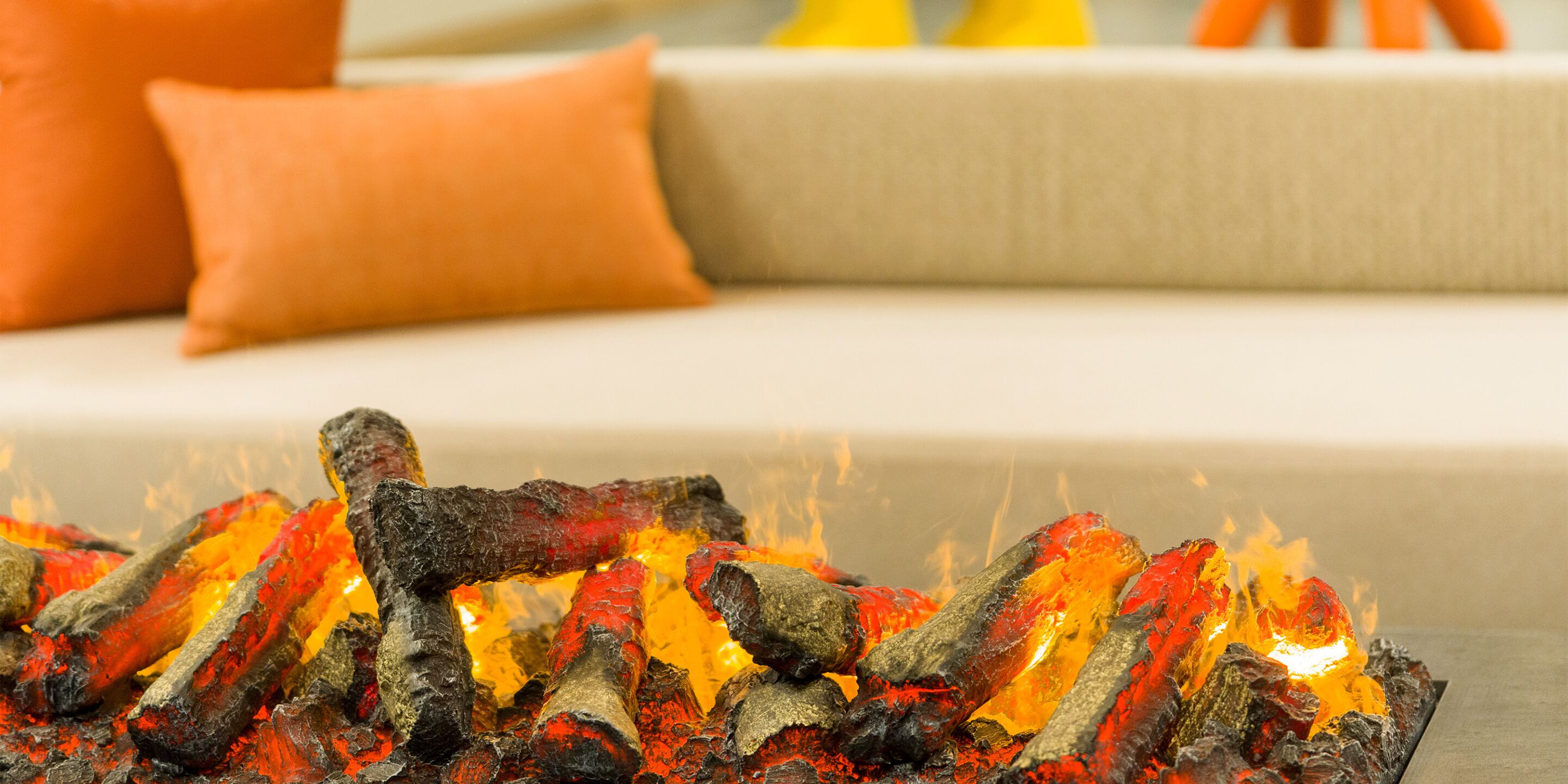 A fireplace with burning logs in a living room.
