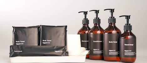A set of toiletries including body towel, shampoo, conditioner, body soap, hand soap, and a toothbrush.