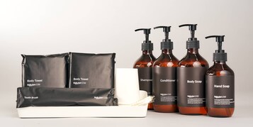 Artigos de higiene pessoal, incluindo toalha de banho, shampoo, condicionador, sabonete líquido para o corpo, sabonete líquido para as mãos e escova de dentes.
