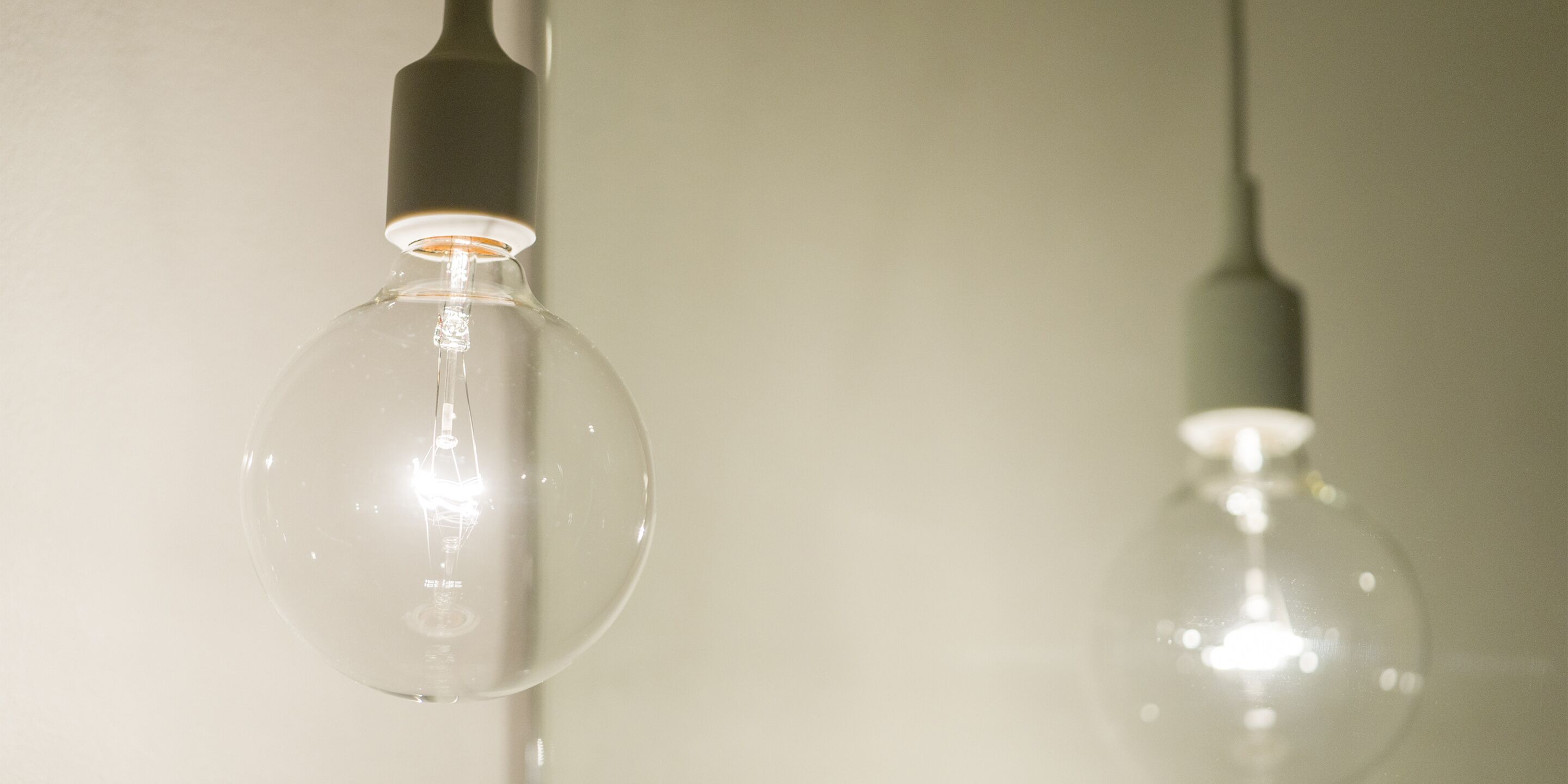 Two clear glass bulbs hanging from a ceiling.