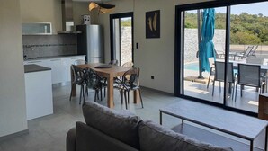 Una cocina moderna con comedor, sofá y vistas al exterior.