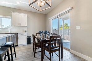 Enjoy meals in this stylish kitchen and dining area, featuring a central island, oven, and dining table for four.
