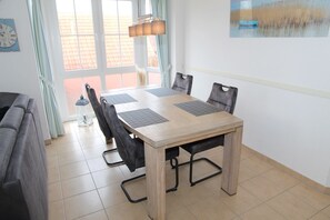 Ein Essbereich mit Holztisch, vier Stühlen und einer Lampe.