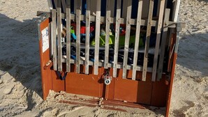 Estructura de madera en la playa con un dosel blanco que dice "Norden Niedersachsen".