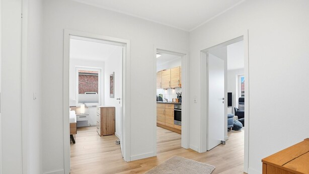 A modern apartment with a kitchen, dining area, and a living space. - Strandfloh - Gemütliche Ferienwohnung mit Fahrstuhl (Norden)