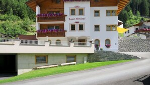 A two-story building with balconies adorned with flowers, labeled "Apart Elfriede." - Cosy apartment for 13 guests with WIFI, TV and balcony (See)
