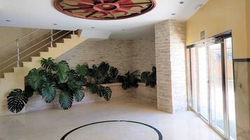 Un'ampia hall con una scala, ampie finestre e un design unico del soffitto.