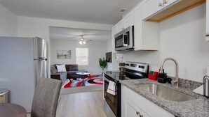 A modern kitchen with white cabinets, stainless steel appliances, and a granite countertop. - Fabulous Retreat! Centrally located. Quiet & Cozy! Sleeps 4. Hi Sp Wifi & more. (Hanahan)