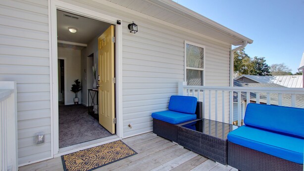 A covered porch with a wicker sofa and a glass table. - Fabulous Retreat! Centrally located. Quiet & Cozy! Sleeps 4. Hi Sp Wifi & more. (Hanahan)