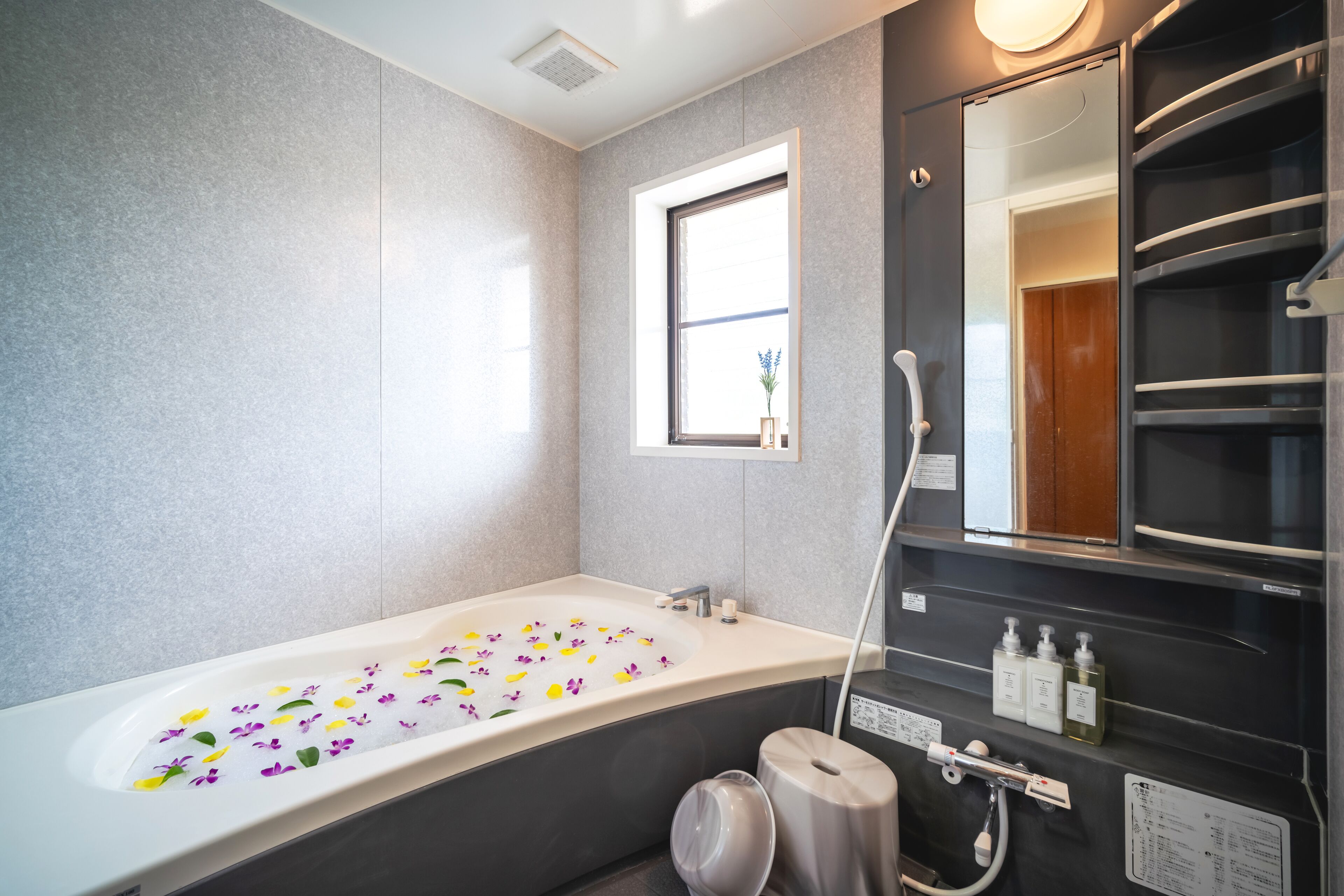 Une salle de bain moderne avec une grande baignoire, une fenêtre et un miroir.