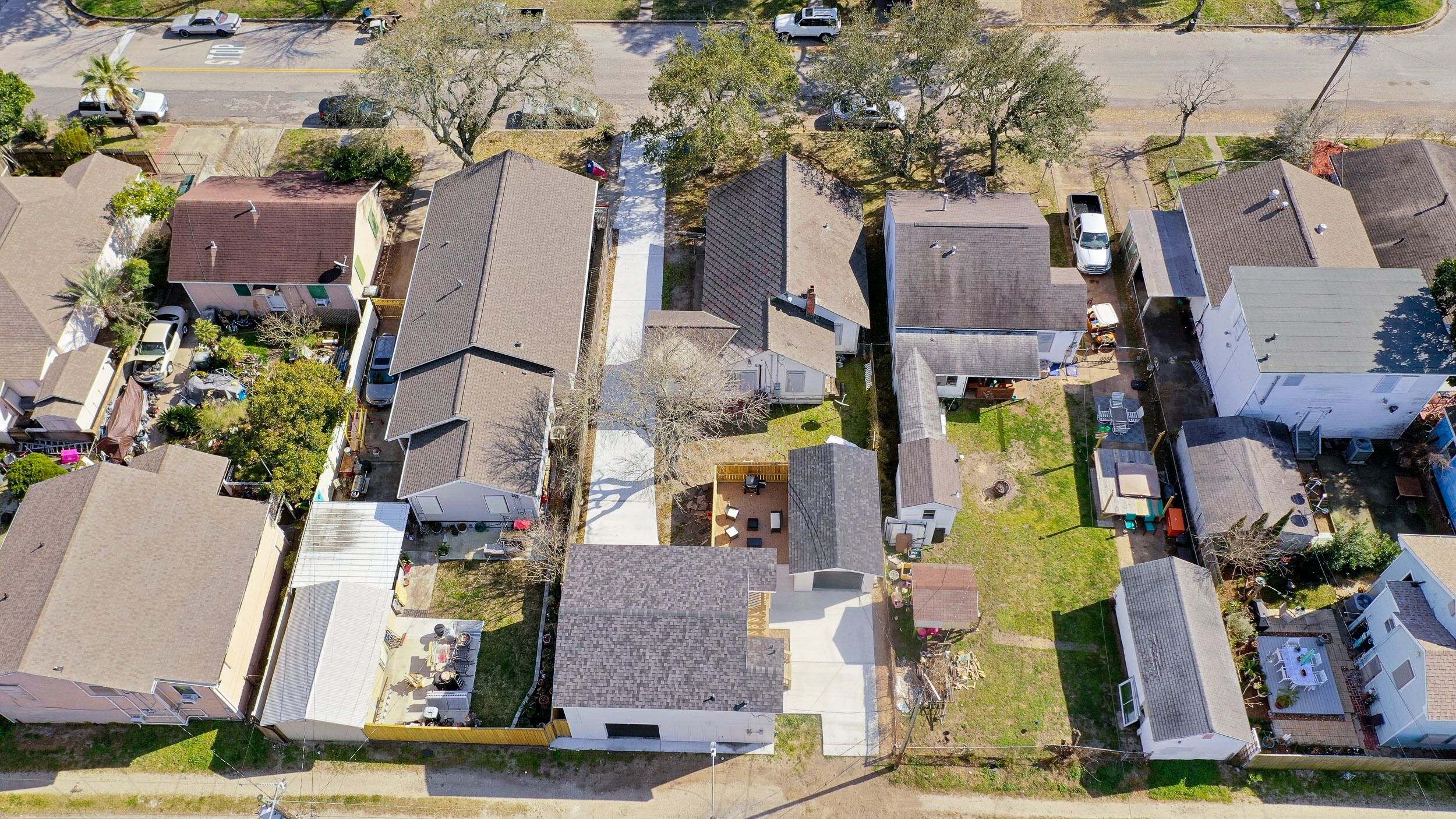 An aerial view of a residential neighborhood with houses, streets, and parked cars.