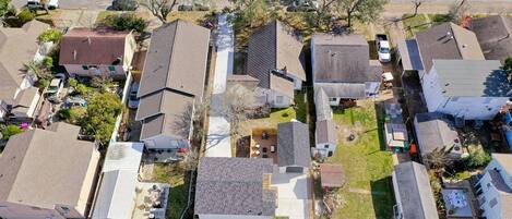 An aerial view of a residential neighborhood with houses, streets, and parked cars.