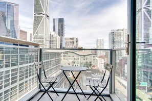 Enjoy the city view from this balcony with a glass railing, perfect for taking in the sights.
