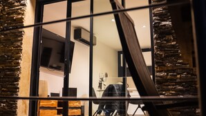 A modern interior with a stone facade, a large sliding glass door, and a wooden floor. - TERRASSE PROVENCE PAGNOL ***** (Aubagne)