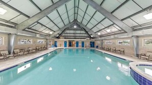 Una piscina interior con techo alto y un tragaluz grande.