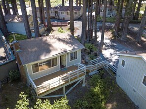A small, single-story cabin with a front deck and a covered porch area. - Masood's Lodge (Boulder Creek)