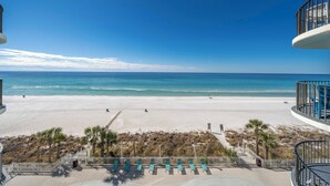 A beach view from a balcony with lounge chairs and a pool area. - Luxury Beach Front Condo (Panama City Beach)
