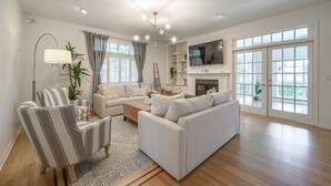 A spacious living room with a sofa set, a television, and a fireplace. - Luxury Harbor Home – Pool, Hot Tub, Basketball Court & Tiki Lounge Near Gulf Beaches (Largo)