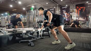 A gym with exercise equipment and a mirrored wall.