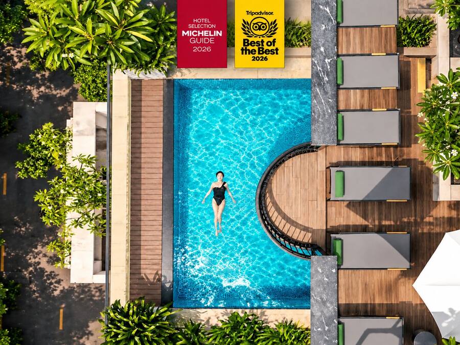 Una piscina con una persona nadando, rodeada de sillas de descanso y sombrillas.