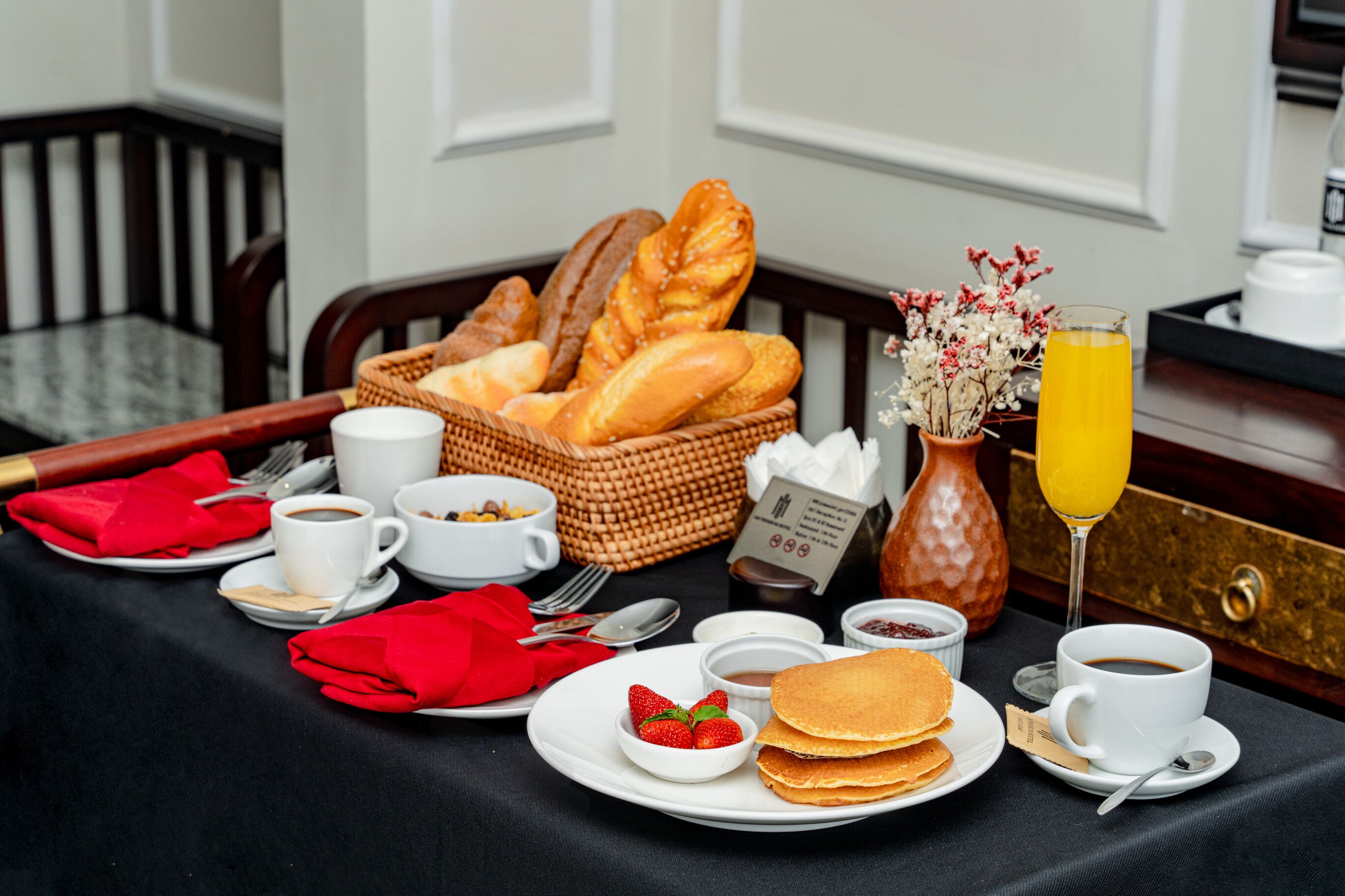 Ein Frühstückstisch mit Brot, Gebäck, Kaffee und Saft.